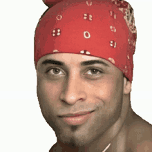 a man wearing a red bandana is smiling and looking at the camera .