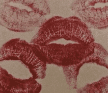 a close up of a woman 's lips with red lipstick on them on a beige background .