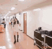 a woman in a pink dress is dancing in a hallway