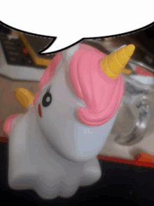 a white unicorn with a pink mane and horn