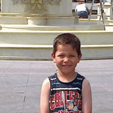 a young boy wearing a tank top with the word college on it