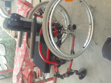 a red and black wheelchair with the word pearl on the side