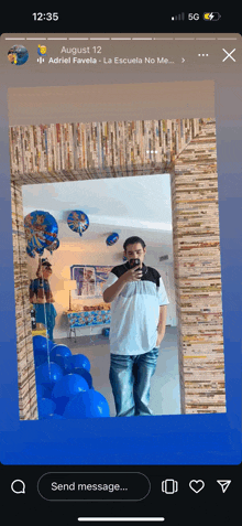 a man is taking a picture of himself in a mirror with balloons in the background