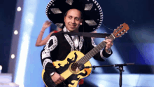 a man wearing a sombrero and holding a guitar