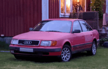 a red audi quattro is parked in the grass