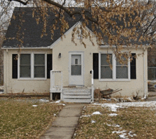 a small white house with black shutters and a sign that says ' a ' on the front