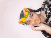 a girl wearing a cat ear mask with flowers on her face