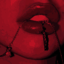 a close up of a woman 's mouth with a cross necklace around her neck