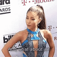 ariana grande is standing on a red carpet with her hands on her hips and talking to the camera .