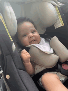 a baby is sitting in a car seat with a warning label on the back