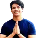 a young man in a blue shirt is smiling with his hands folded in prayer .