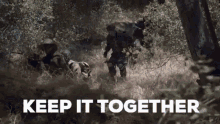 a group of soldiers are walking through a lush green forest with the words `` keep it together '' written in the foreground .