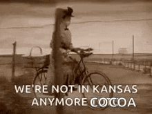 a woman is riding a bicycle down a dirt road in a black and white photo with a quote .