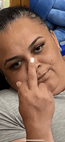 a woman with white nails is giving the middle finger to the camera