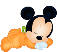 a baby mickey mouse is sleeping on a pumpkin