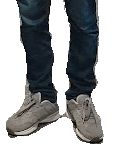 a person wearing a pair of grey sneakers and jeans .