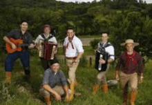 a group of men are posing for a picture in a field .