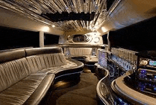 the inside of a limousine with a bar , couch , and chairs .