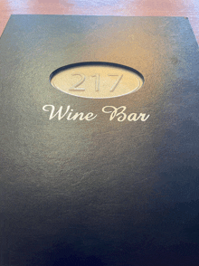 a menu for the 217 wine bar is on a table