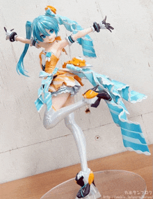 a statue of hatsune miku is on a table with the website http://ameblo.jp/esc-nikatan/