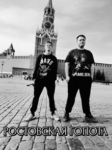 two men are standing in front of a clock tower with the words " ростовская гопота " written below them