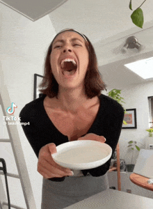 a woman is holding a white plate with her mouth open and a tiktok watermark on the bottom