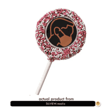 a lollipop covered in pink and white sprinkles with a picture on it