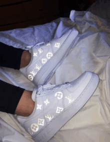 a pair of white nike air force 1 sneakers with louis vuitton logos on them