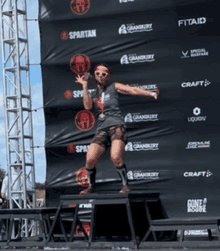 a woman is standing on a box in front of a banner that says spartan