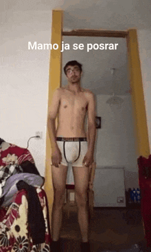 a shirtless man in boxer shorts is standing in a room .