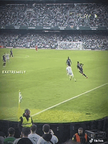 a soccer game is being played in a stadium with a play button in the background