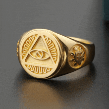 a gold ring with an eye in a triangle