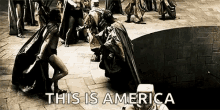 a black and white photo of a group of people standing next to each other on a brick floor .