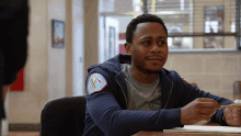 a man sitting at a desk with a patch on his sleeve that says fire