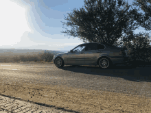 a silver car is parked on the side of a road