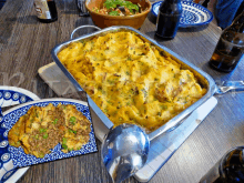 a casserole dish with a spoon and a plate of food on a table