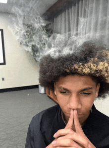 a young man with a smoke coming out of his afro