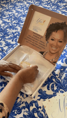 a woman is opening a box with a picture of a woman and a quote from proverbs 37