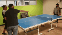 a group of people are playing ping pong on a table