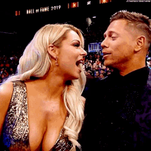 a man and a woman are looking at each other in front of a crowd at the hall of fame in 2019