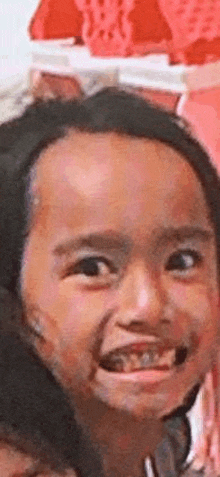 a young girl with braces on her teeth is smiling for the camera .