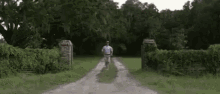 a man is running down a dirt road in a field with the words haag i written on the bottom .