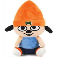 a stuffed animal with an orange hat and blue shirt is sitting on a white background .