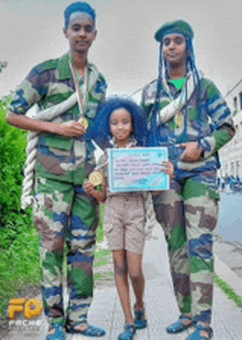 three people in military uniforms are posing for a picture with a little girl holding a certificate