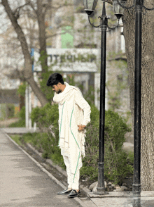 a man standing on a sidewalk in front of a sign that says ' utechsp '