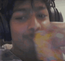 a man wearing headphones is eating a snack