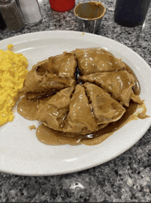 a white plate topped with a pancake with peanut butter sauce and scrambled eggs