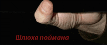 a close up of a person 's finger with the words " шлюха поимана " written in red