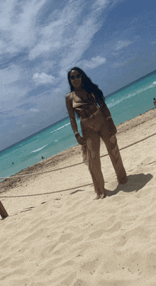 a woman in a bikini is standing on a beach