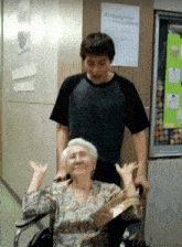 a man stands next to an elderly woman in a wheelchair in front of a sign that says ' nurses '